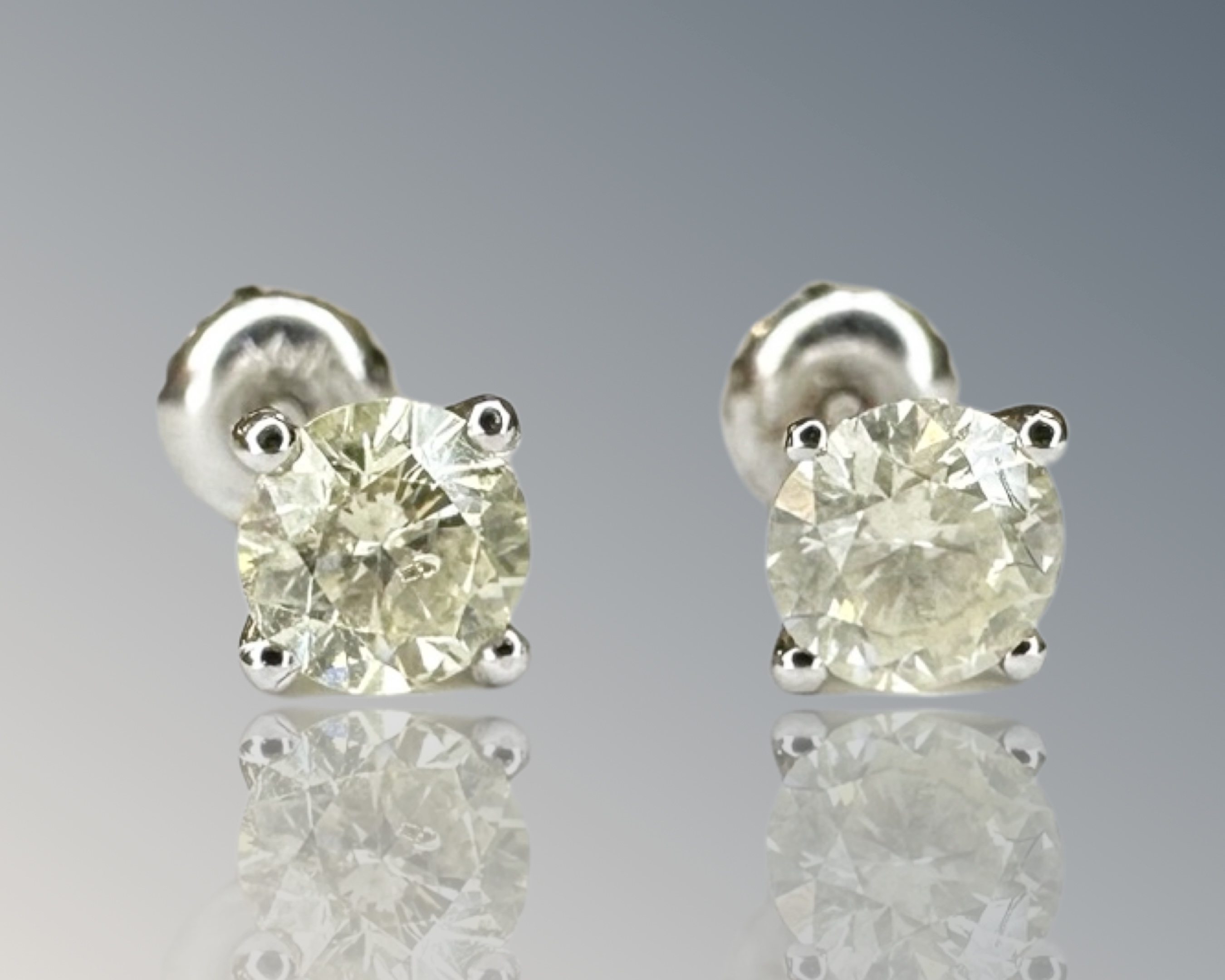 A pair of diamond stud earrings, the brilliant cut stones total 1.