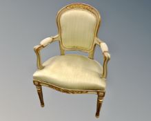 A cream and gilt French salon armchair.