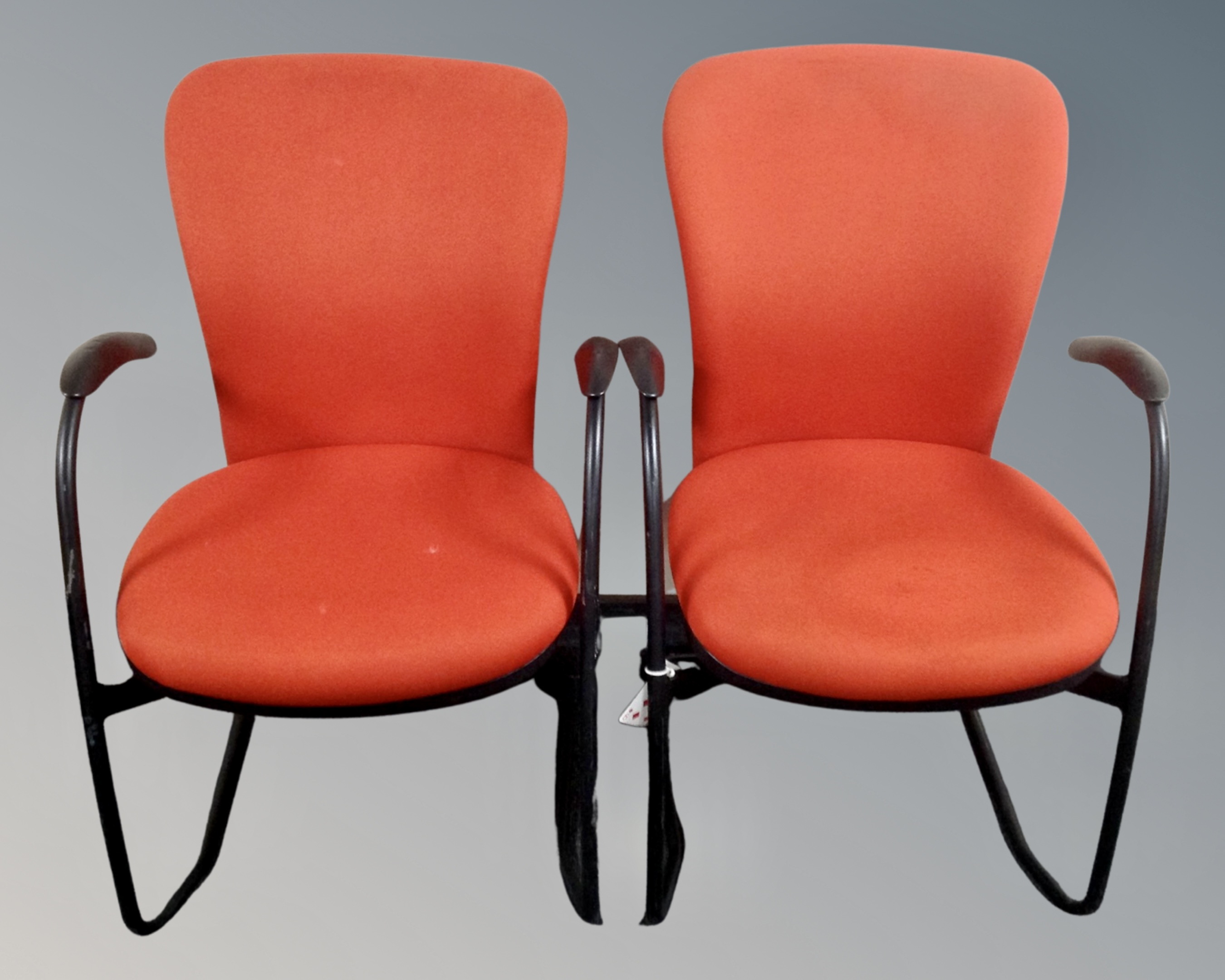 A pair of retro style office armchairs.