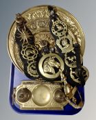 A tray of brass embossed plaques, horse brasses on leather straps,