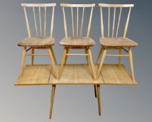 A set of three Ercol elm and beech spindle back dining chairs together with a further mid-20th