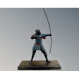 A warrior figure with long bow, mounted on wooden plinth, height 32 cm.