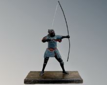 A warrior figure with long bow, mounted on wooden plinth, height 32 cm.