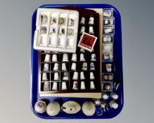 A collection of assorted china thimbles, thimble rack, three piece ceramic cruet set,
