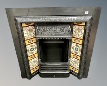 A Victorian cast iron tiled fire insert complete with bars, fire back, tidy and ash tray,