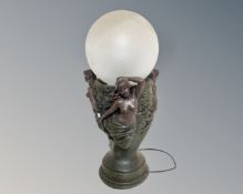 An Art Nouveau style cast plaster table lamp with clouded glass shade.