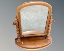 A Victorian mahogany dressing table mirror on bobbin supports.