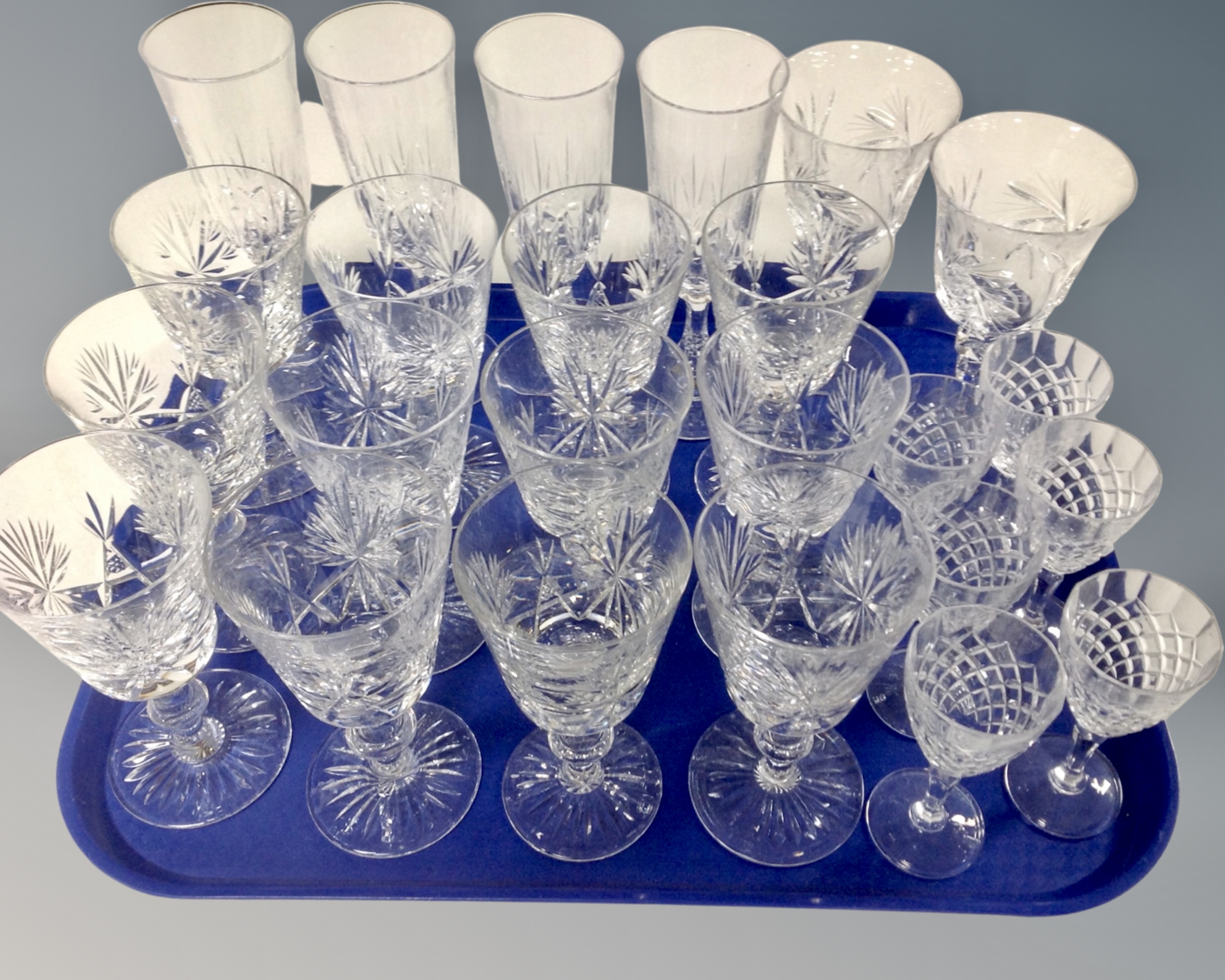 A tray of assorted drinking glasses to include a set of twelve lead crystal wine glasses