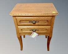 A continental oak two drawer bedside table on raised legs (width 44cm)