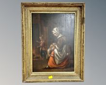 18th century school : A woman consoling a child by the fire, oil on panel, in gilt frame,