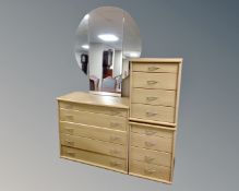 A five drawer dressing chest with triple mirror together with a pair of four drawer bedside chests