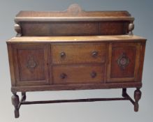 An Edwardian oak double door buffet back sideboard on raised legs fitted with two drawers (width