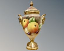 A Coalport porcelain lidded vase painted with fruit by A Baggett, height 21cm.