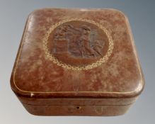 An embossed leather box containing sewing accessories.