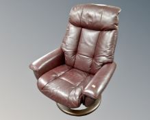 A Burgundy leather swivel adjustable armchair.