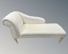 A contemporary chaise longue upholstered in white fabric.