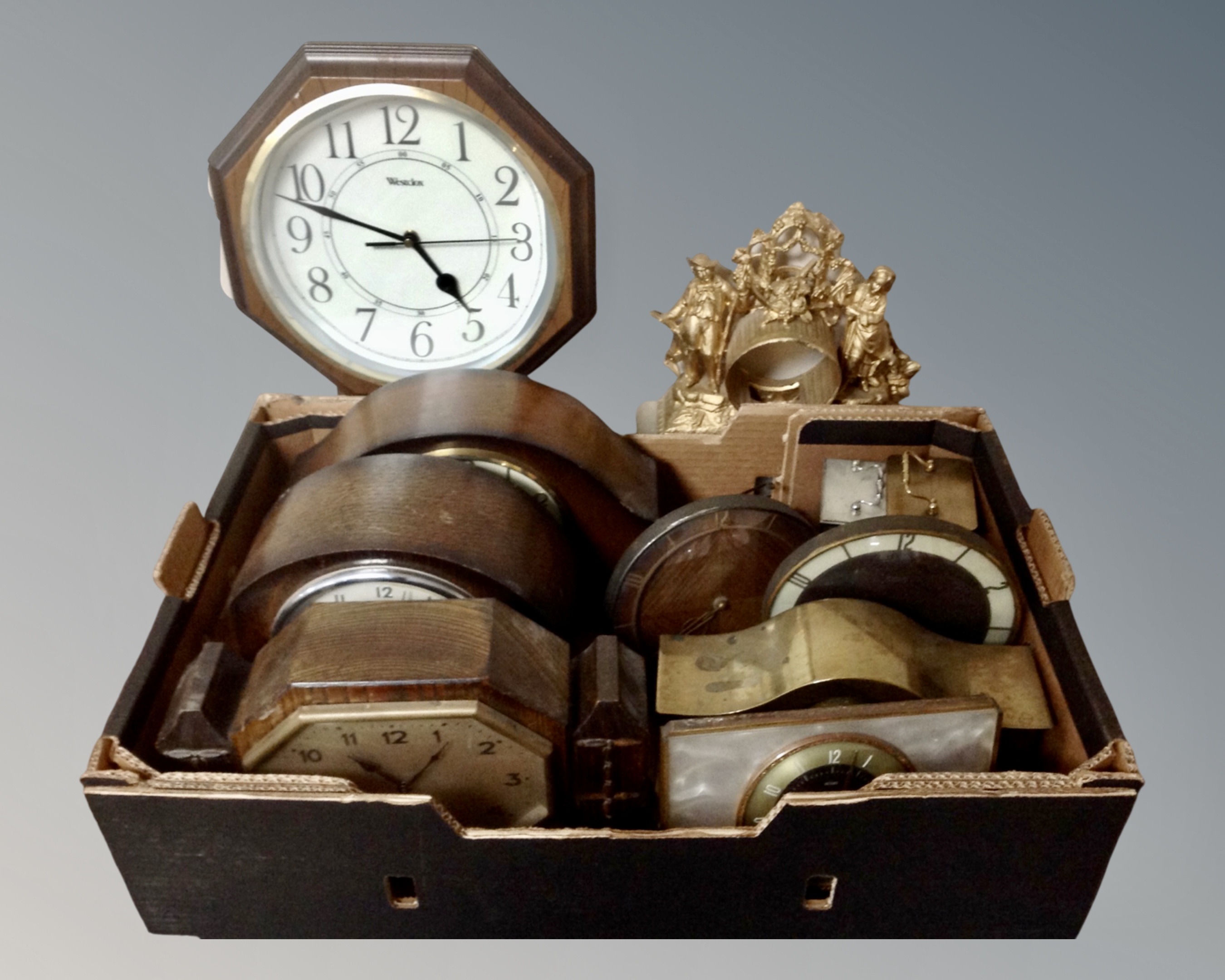 A box of 20th century oak and brass mantel and carriage clocks.