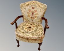 A 20th century stained beech open armchair upholstered in gold brocade fabric.