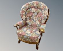 An Ercol fireside armchair upholstered in a floral fabric.