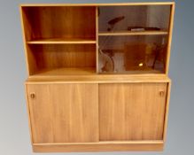 A mid-20th century teak double door sliding cabinet, fitted with bookcase above.