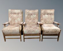 Three beech framed fireside chairs upholstered in a pink brocade fabric.