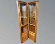 A pair of McIntosh furniture teak glazed door corner cabinets fitted with cupboards beneath.