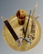 A resin ashtray inset with a fishing fly together with two cigar cutters,