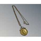A George V gold half sovereign in 9ct gold mount with 9ct gold chain, 9.6g.