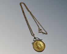 A George V gold half sovereign in 9ct gold mount with 9ct gold chain, 9.6g.