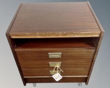 A three drawer chest with brass drop handles.