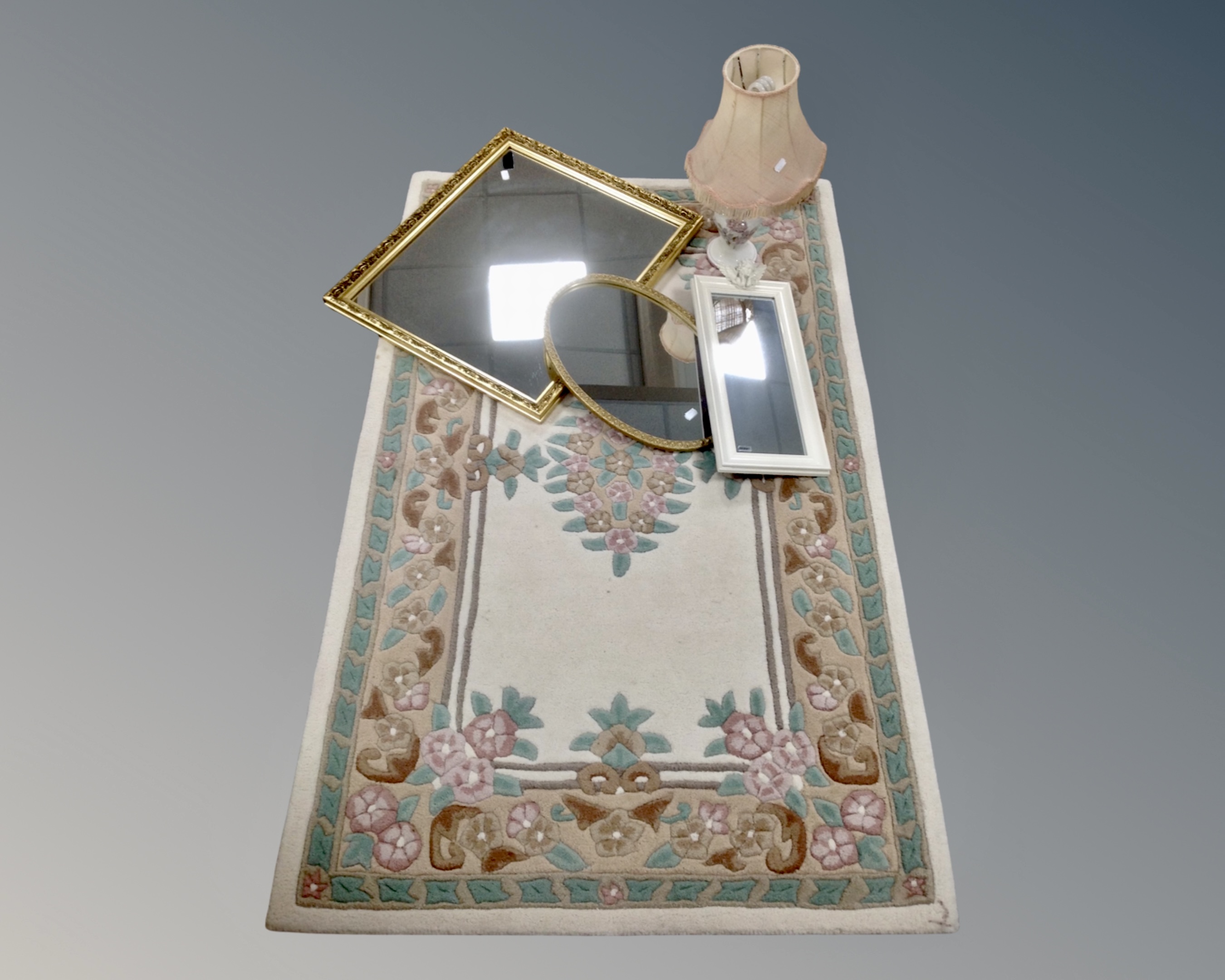A floral embossed rug on cream ground together with a ceramic table lamp with shade and three