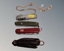 An Ogden's tobacco tin containing a vintage pocket knife and three Swiss army knives.