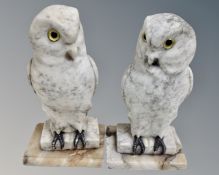 A pair of carved alabaster owl bookends with glass eyes.