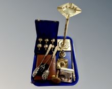 A tray containing a cased set of six miniature brass goblets, a brass ash tray on raised stand,