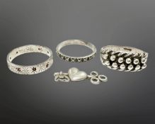 Three silver rings and a key and heart charm.
