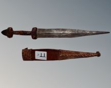 A tribal dagger in leather sheath.