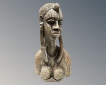 A carved African bust of a woman.