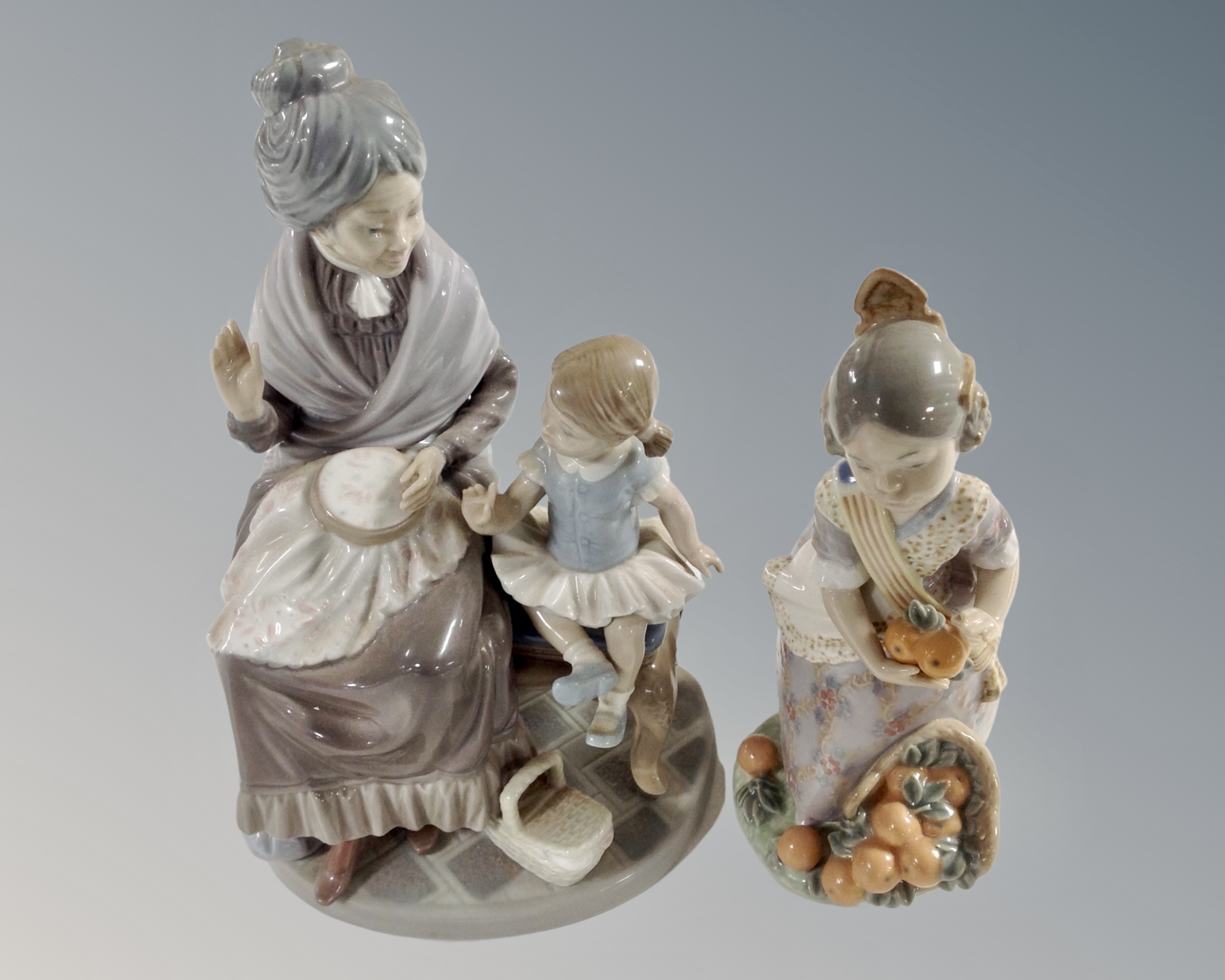 A Lladro figure Girl with Grandmother together with a further Lladro figure of a girl picking