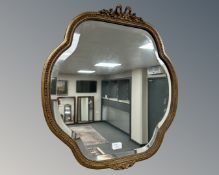 A 20th century shaped and bevelled mirror, 59cm by 62cm.