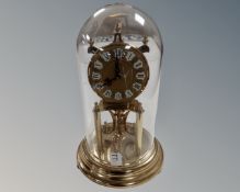 A brass Kundo clock under dome.