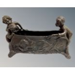 A cast bronze planter surmounted by cherubs.