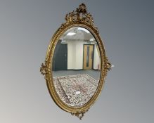 A 19th century style oval gilt framed mirror, 105cm by 70cm.