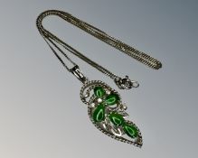 A 9ct white gold jade and diamond pendant on 14ct gold chain.