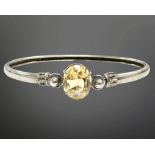 A Scottish silver and citrine bangle, 64mm by 56mm, the oval-cut citrine 12.5mm by 10mm.
