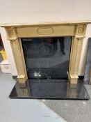 A gilt wooden fire surround and black granite hearth