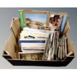 A box of assorted 20th century postcards.