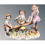 A continental porcelain figure group of children on a see-saw.