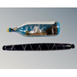 A Nailsea type antique glass rolling pin and a ship in bottle.