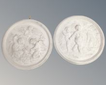 Two circular plaster relief plaques depicting putti.