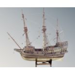 A wooden model of a galleon on stand.